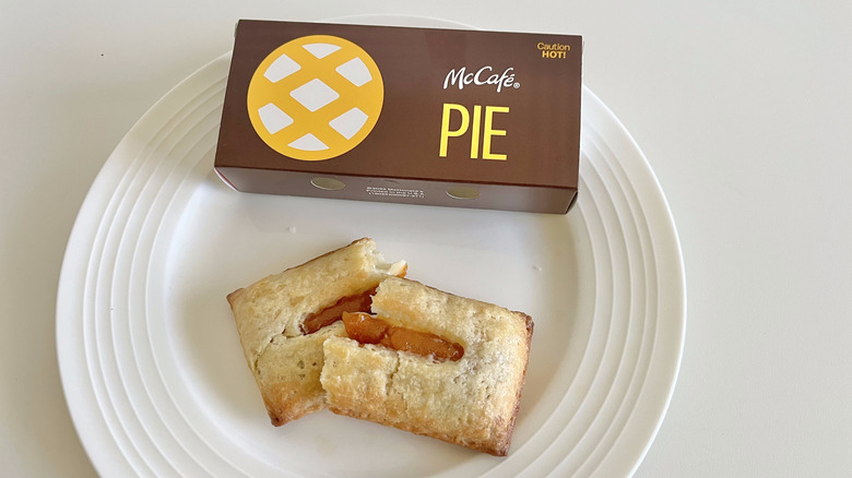 McDonald's Pumpkin Crème Pie cut in half on a plate next to the packaging
