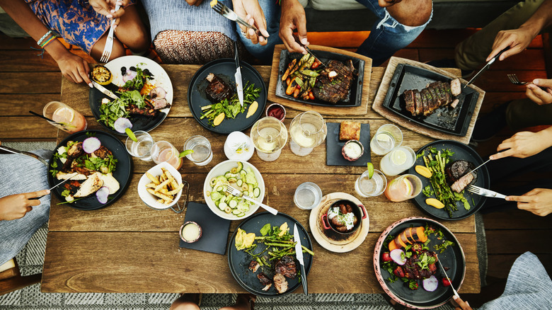 food on table; dishes with food; wine glasses