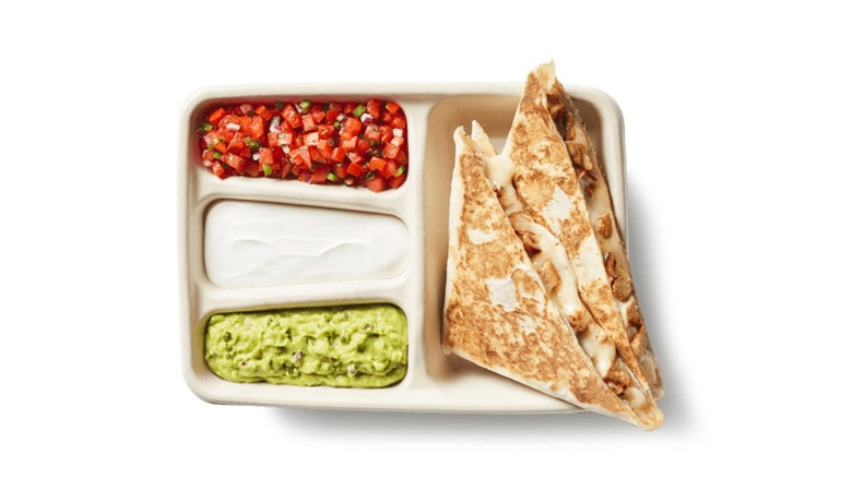 Chipotle quesadilla in a tray with salsa, sour cream, and guacamole