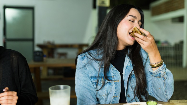 Woman enjoying a quesadilla in a restaurant.