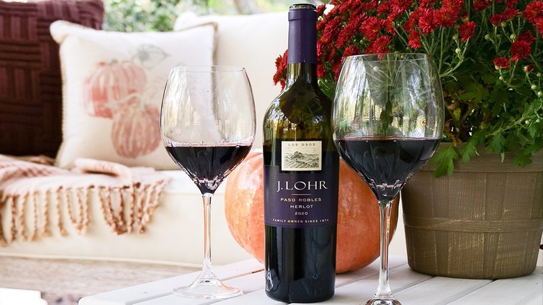 Bottles of J Lohr Los Osos Merlot and glasses