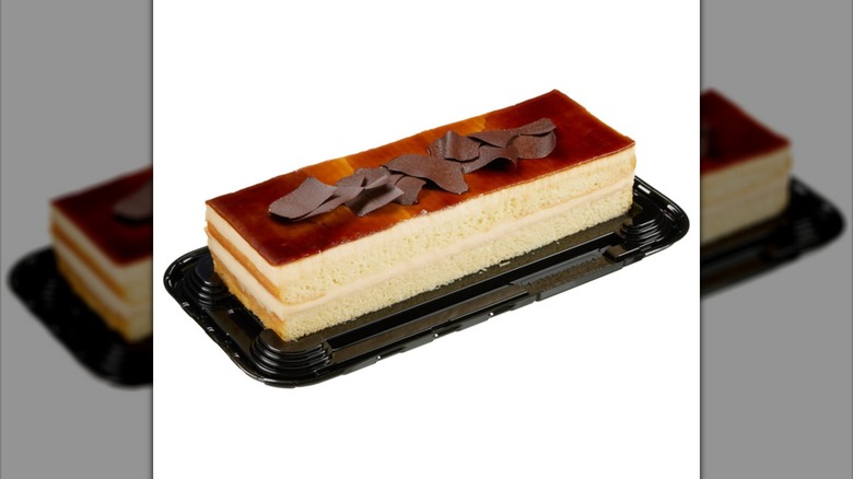Rectangular tres leches cake on black plastic tray