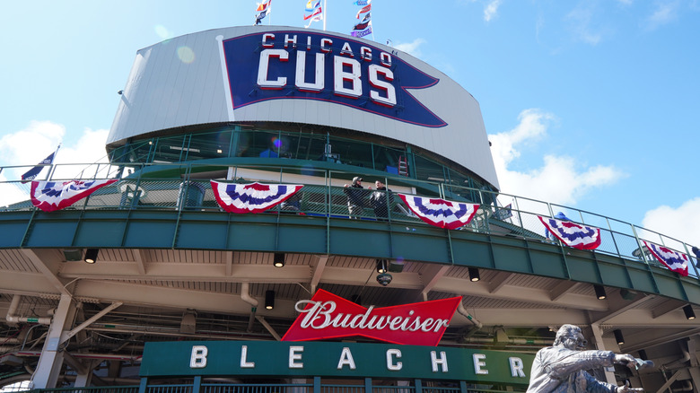A wrigley field chicago cubs sign overlooking the bleachers section of the stadium