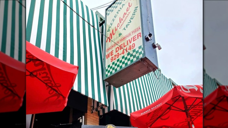 The striped awning and outside sign for Michael's Pizza