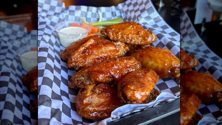 bone-in chicken wings on checkered deli paper from output bar in wrigleyville