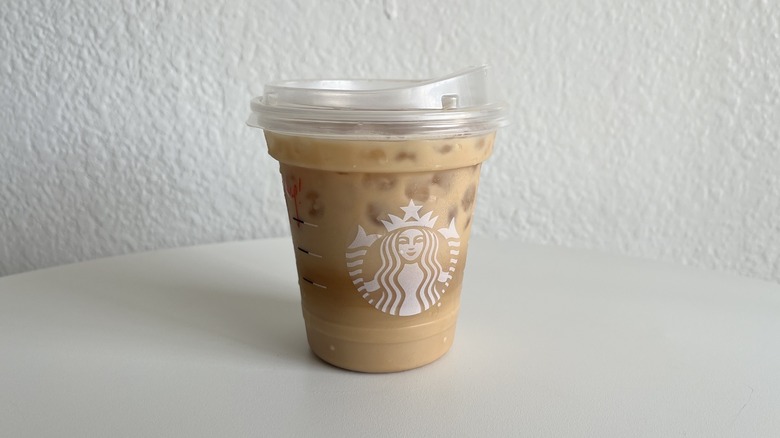 Cup of Iced Hazelnut Oatmilk Shaken Espresso on table