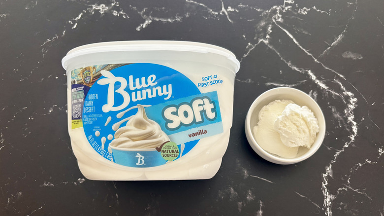 Blue Bunny vanilla ice cream tub next to small bowl of ice cream