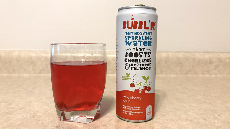 Bubbl'r Wild Cherry Chill'r in can and glass on neutral background.