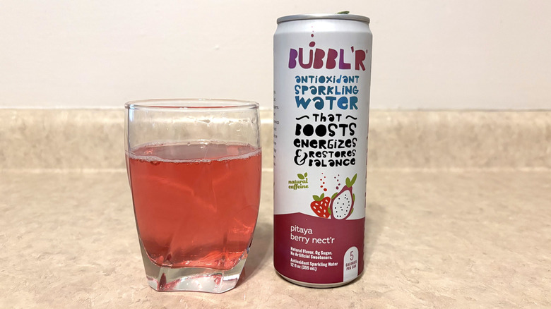 Bubbl'r Pitaya Berry Nect'r in can and glass on neutral background.