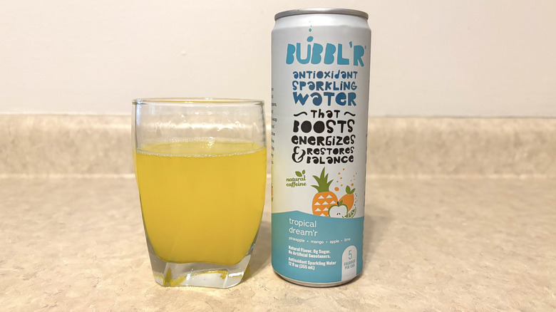 Bubbl'r Tropical Dream'r in can and glass on neutral background.