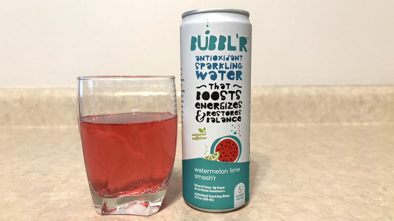 Bubbl'r Watermelon Lime Smash'r in can and glass on neutral background.