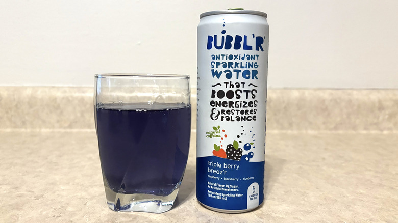 Bubbl'r Triple Berry Breez'r in can and glass on neutral background.