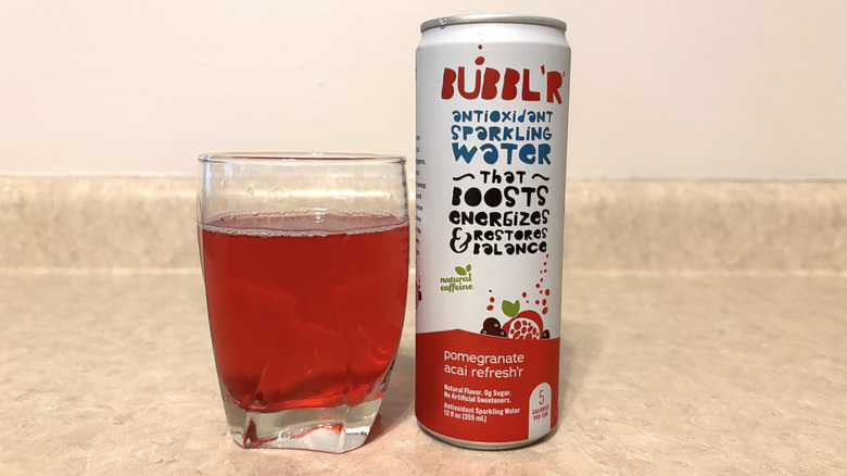 Bubbl'r Pomegranate Acai Refresh'r in can and glass on neutral background.