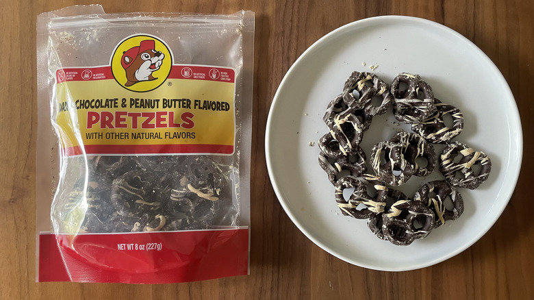 Buc-ee's chocolate and peanut butter covered pretzels on a plate and in a bag