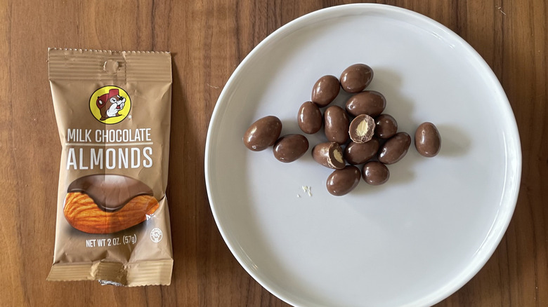 Milk chocolate almonds on a plate and with packaging