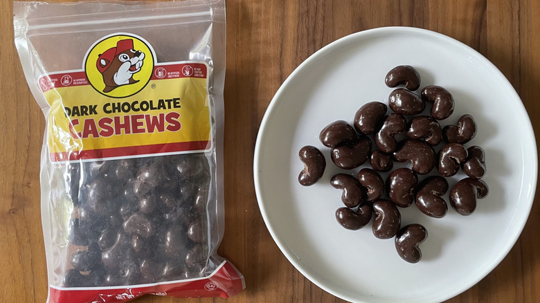 Dark chocolate cashews on a plate and in a bag