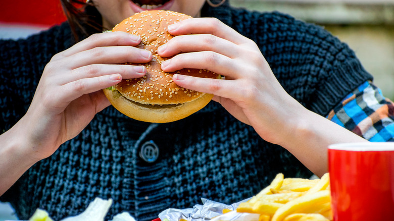 A child eating a hamburger at a fast food restaurant