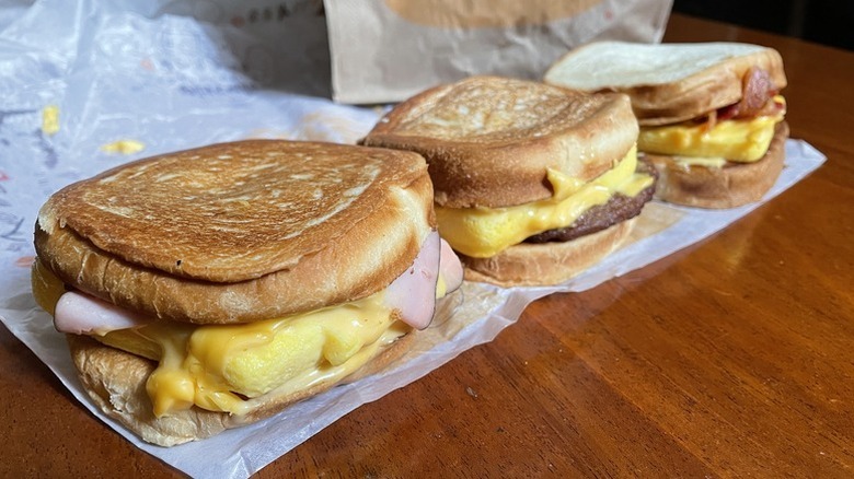 Three Burger King Breakfast Melts sitting on white parchment paper wrapper