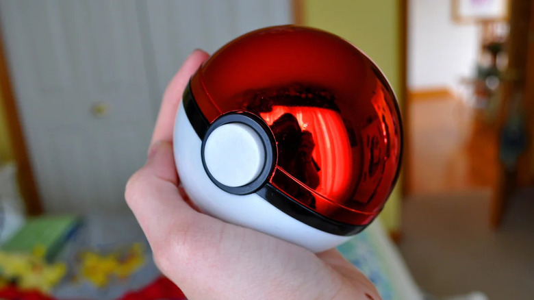Close up of hand holding a toy Pokémon ball
