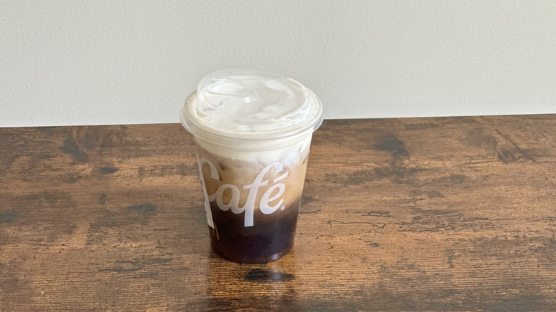 Plastic McDonald's cup of Original Cloud Iced Coffee on wooden table