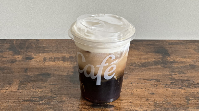 Plastic McDonald's cup of Salted Caramel Cloud Iced Coffee on wooden table