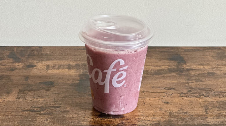 Plastic McDonald's cup of Blueberry Pomegranate Smoothie on wooden table