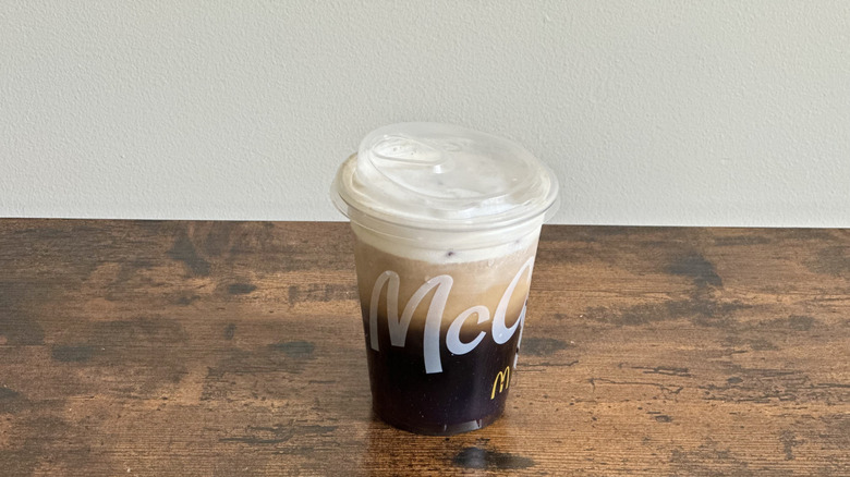 Plastic McDonald's cup of French Vanilla Cloud Iced Coffee on wooden table