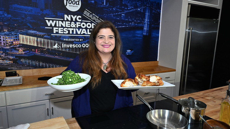 Chef Alex Guarnaschelli holding two dishes