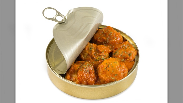 Open can of meatballs on white background