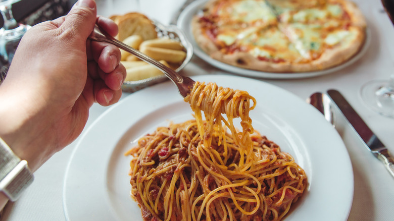 Person eating pasta in a restaurant