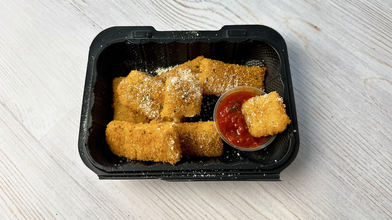 Olive Garden fried mozzarella with marinara dipping sauce in a takeout container