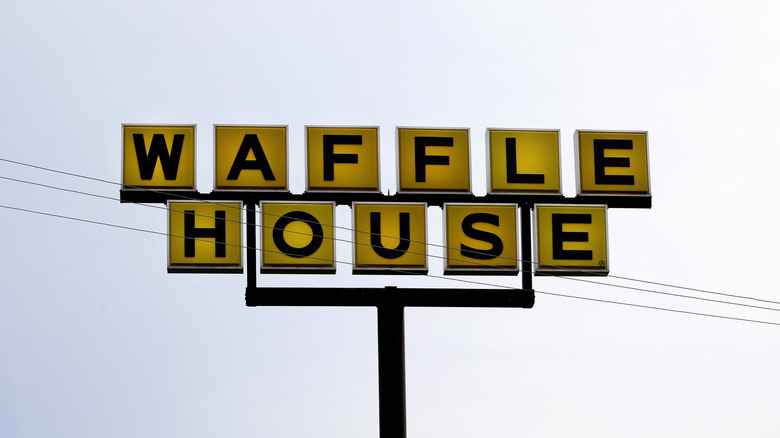 Waffle House sign against cloudy sky