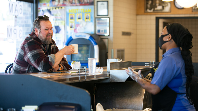 Waffle House employee wearing a mask talking to patron