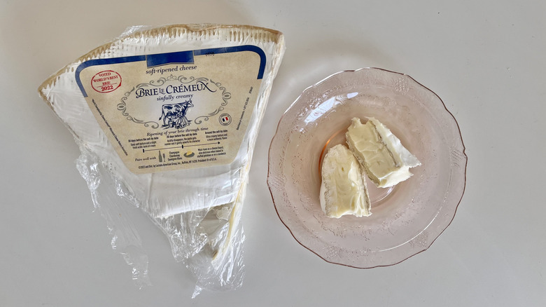 Two slices of Brie Le Crémeux Triple Cream Brie on a plate