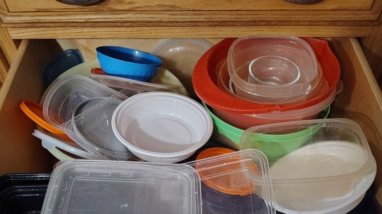 A messy Tupperware drawer with assorted plastic containers