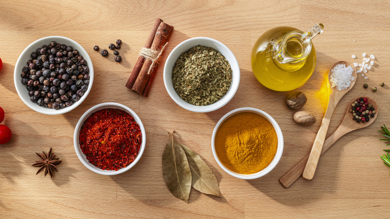 herbs and spices in bowls on a wooden table