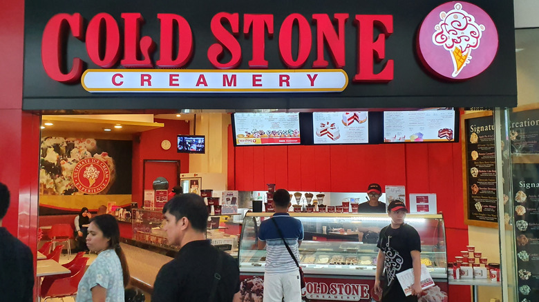 People ordering and working at a Cold Stone Creamery store counter
