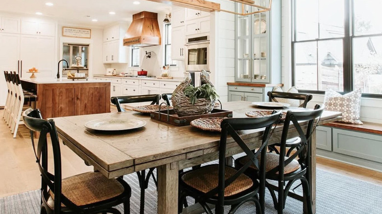 A huge kitchen and dining room shared space with a massive kitchen island as well as a large kitchen table