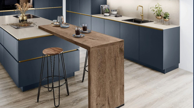 An add-on kitchen counter that rests on one side of a kitchen island