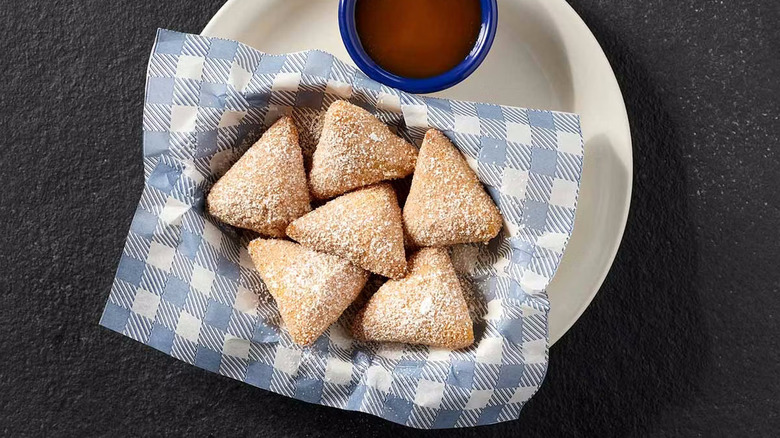 Cracker Barrel beignets on white plate with dipping sauce