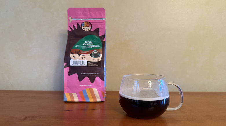 Glass of coffee on wooden table with bag of Irish cream coffee