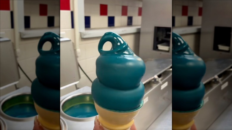 Blue raspberry dipped cone in front of dipped cone liquid and dairy counter