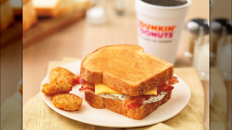 A plate with a breakfast sandwich and hash browns