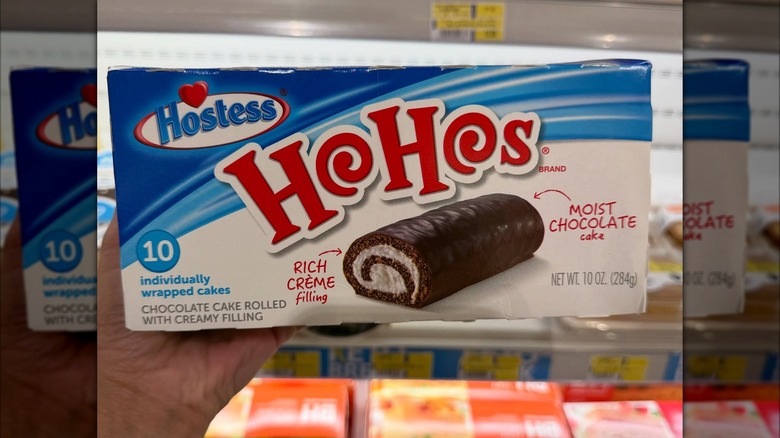 A box of Hostess Ho Hos showing swirled chocolate cake with cream filling on a white and blue backdrop