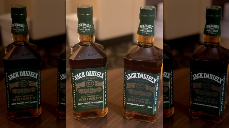 Two bottles of Green Label Jack Daniel's on wooden table