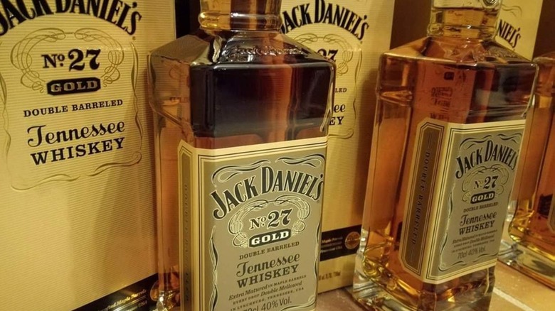 Bottle of Jack Daniel's No 27 Gold with rocks glass and ice