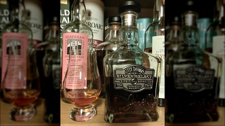 Bottle and glass of Silver Select with other bottles in background