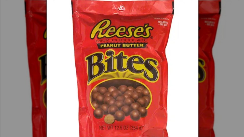 An orange bag of Reese's Peanut Butter Bites, showing a pile of chocolate balls spilling out of a yellow frame.