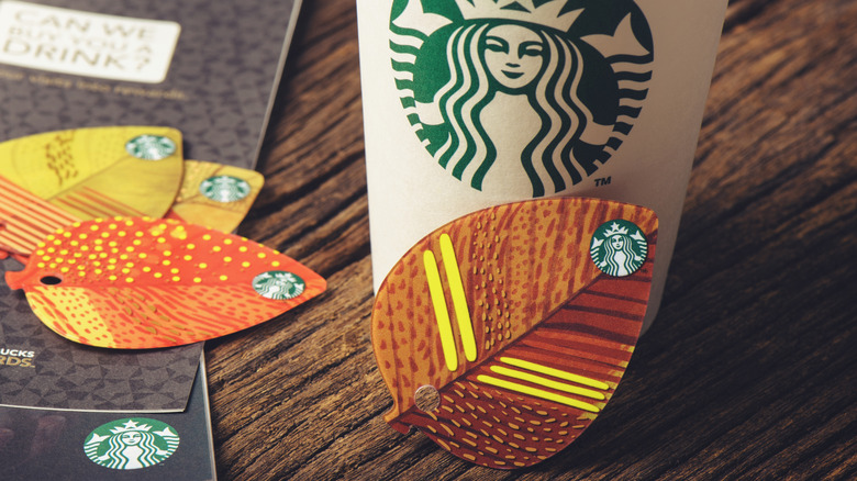 Starbucks cup with artsy paper fall leaves on a table