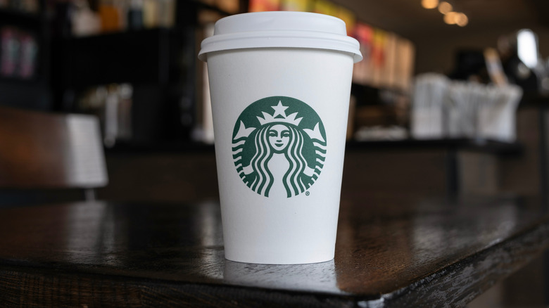 Starbucks cup sitting on dark wooden countertop